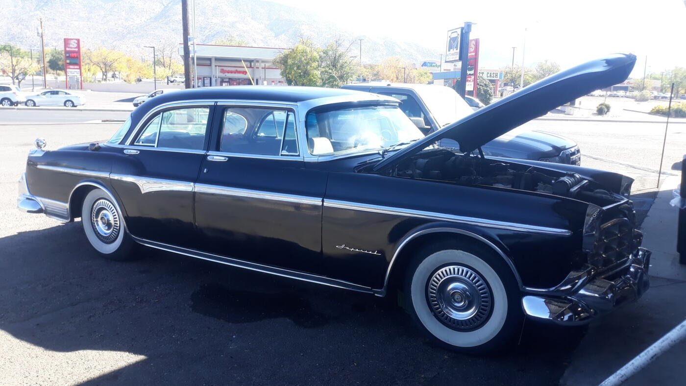 Classic sedan with the hood open at dusk