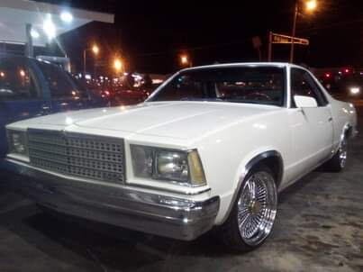 Lowered classic car with chrome wheels at night