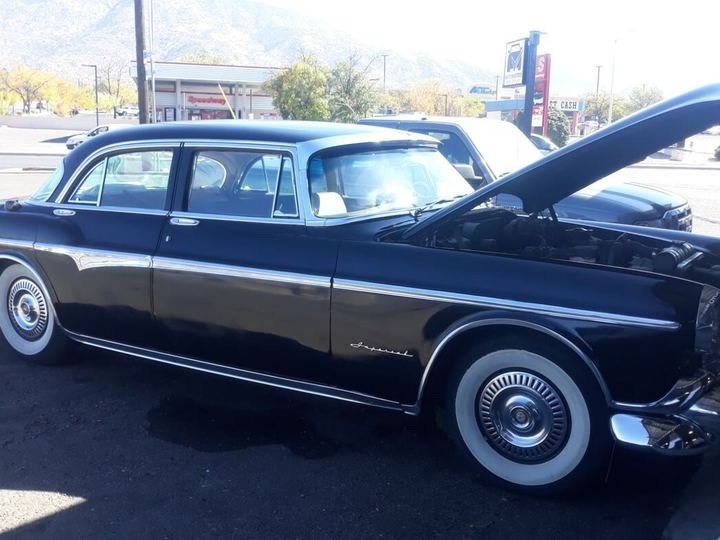 Classic sedan with the hood open at dusk
