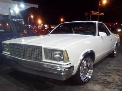 Lowered classic car with chrome wheels at night
