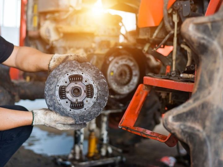 Mechanic inspecting a clutch plate during a repair